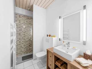 This modern bathroom features a sleek design with a wooden vanity and a stylish sink.