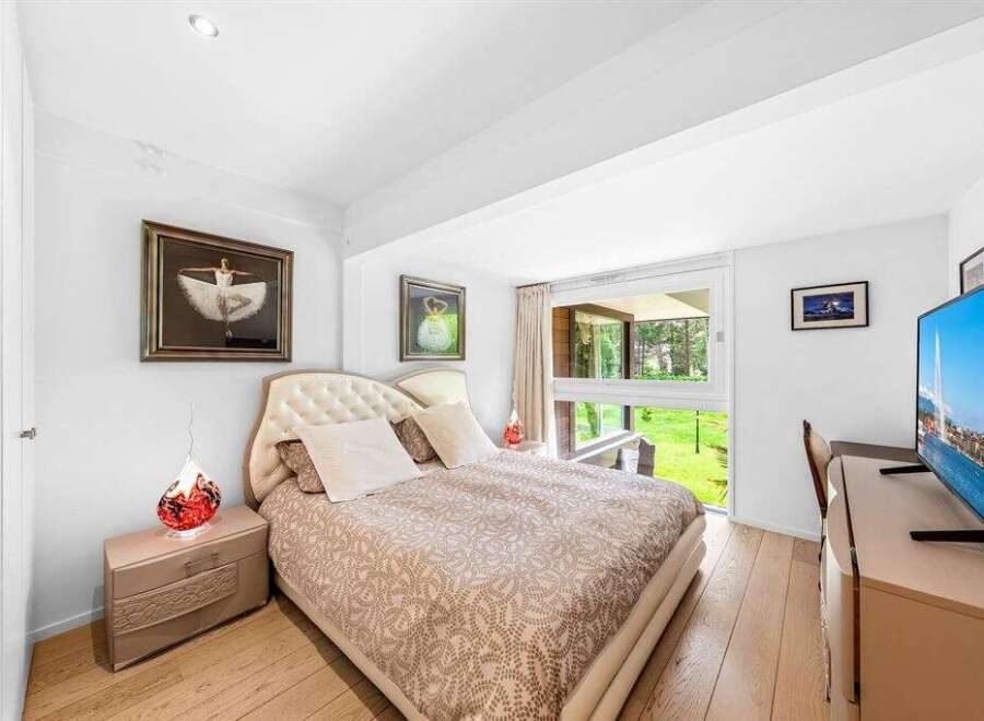This stunning bedroom offers a serene retreat with its elegant design and natural light.