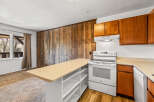 This charming kitchen boasts a unique wooden accent wall, adding warmth and character to the space.
