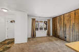 This inviting living space features a stunning wood-paneled accent wall, adding warmth and character to the room.