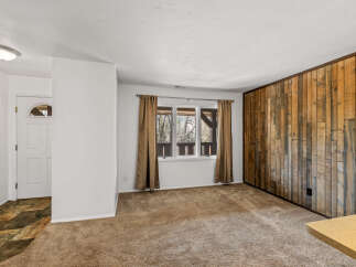 This inviting living space features a stunning wood-paneled accent wall, adding warmth and character to the room.
