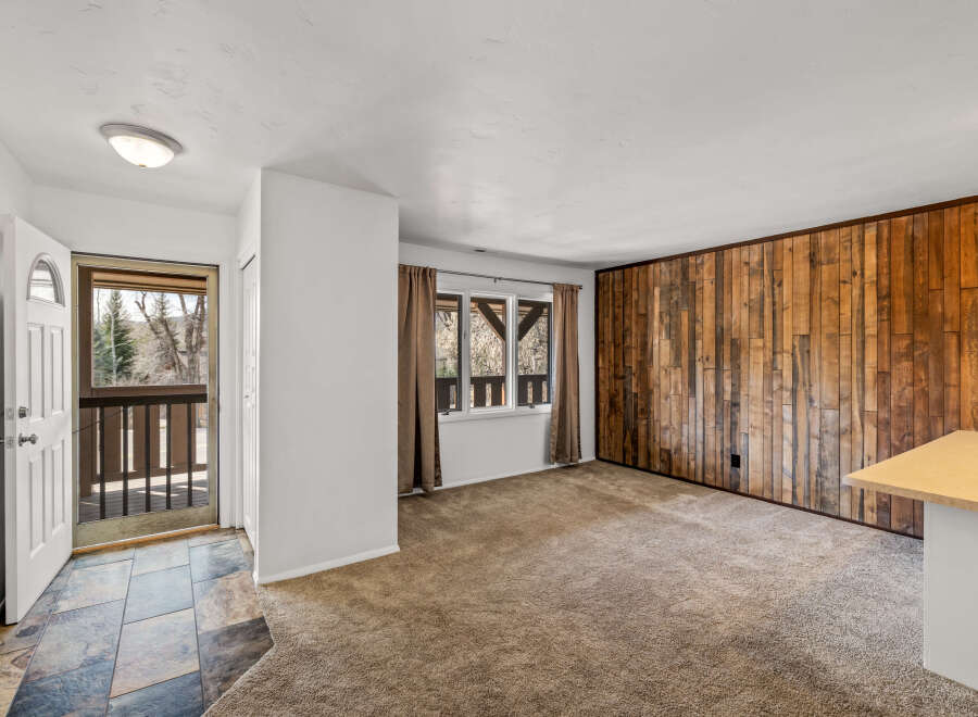 Step into this inviting space, featuring a unique wood-paneled accent wall that adds warmth and character.