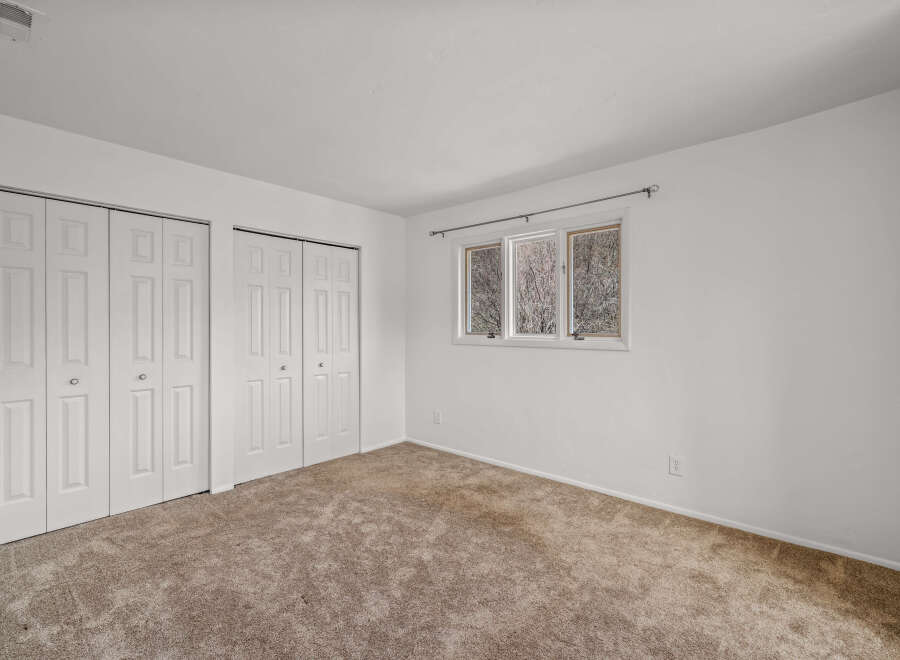 This inviting bedroom features ample closet space and a neutral color palette, offering a blank canvas for personalization.