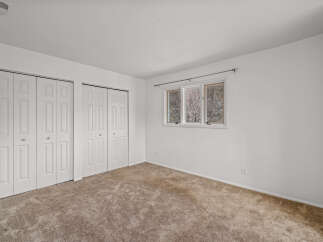 This inviting bedroom features ample closet space and a neutral color palette, offering a blank canvas for personalization.