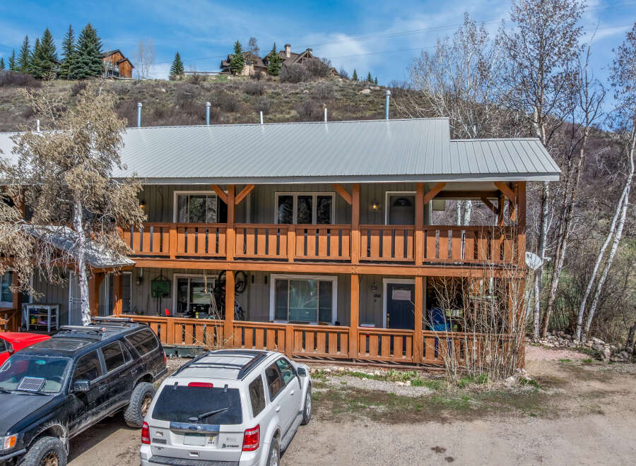 This charming two-story property boasts a rustic design with wooden balconies and a metal roof, offering a blend of mountain living and modern comfort.