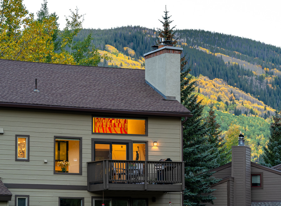 Mountain view home with a balcony and large windows.
