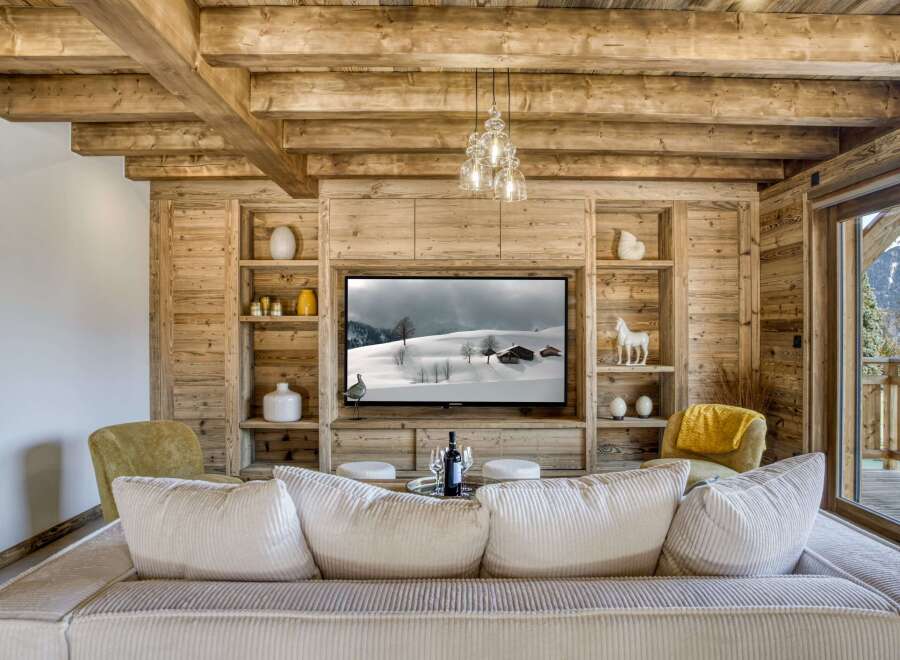 This stunning living room showcases a cozy ambiance with its wooden paneling and exposed beams, creating a warm and inviting atmosphere.