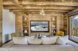 This stunning living room showcases a cozy ambiance with its wooden paneling and exposed beams, creating a warm and inviting atmosphere.