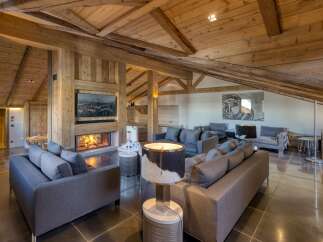 Experience luxury living in this stunning chalet, featuring a cozy fireplace and a modern kitchen.