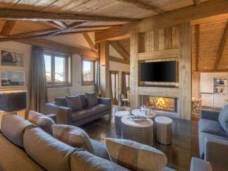 Experience luxury living in this stunning property, featuring a cozy fireplace and a modern entertainment setup.