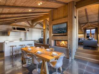 Experience luxury living in this stunning chalet, featuring a cozy fireplace and a modern kitchen.
