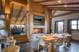 Experience luxury living in this stunning chalet, featuring a cozy fireplace and a modern dining area.
