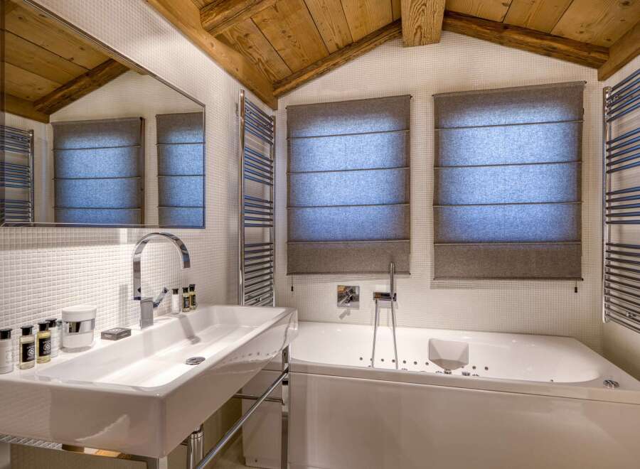 This luxurious bathroom features a modern design with a sleek white sink and a relaxing jacuzzi tub.