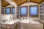 This luxurious bathroom features a modern design with a sleek white sink and a relaxing jacuzzi tub.