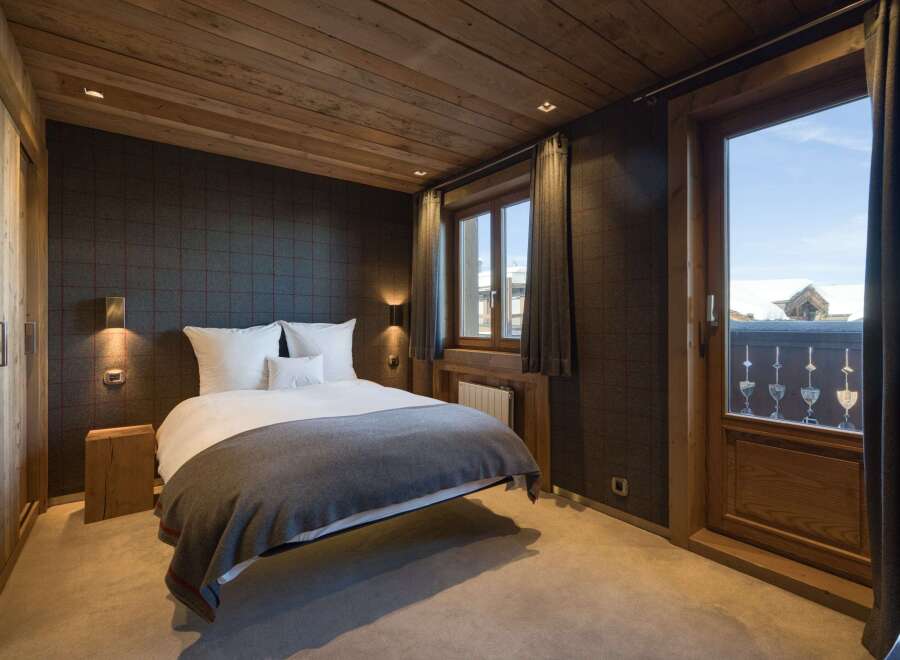 This cozy bedroom features a rustic wooden ceiling and walls, creating a warm and inviting atmosphere.