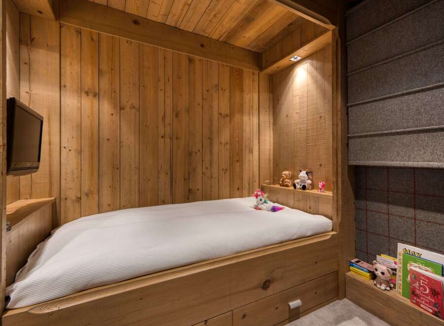 This cozy bedroom features a custom-built wooden bed frame, creating a warm and inviting atmosphere.