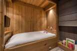 This cozy bedroom features a custom-built wooden bed frame, creating a warm and inviting atmosphere.