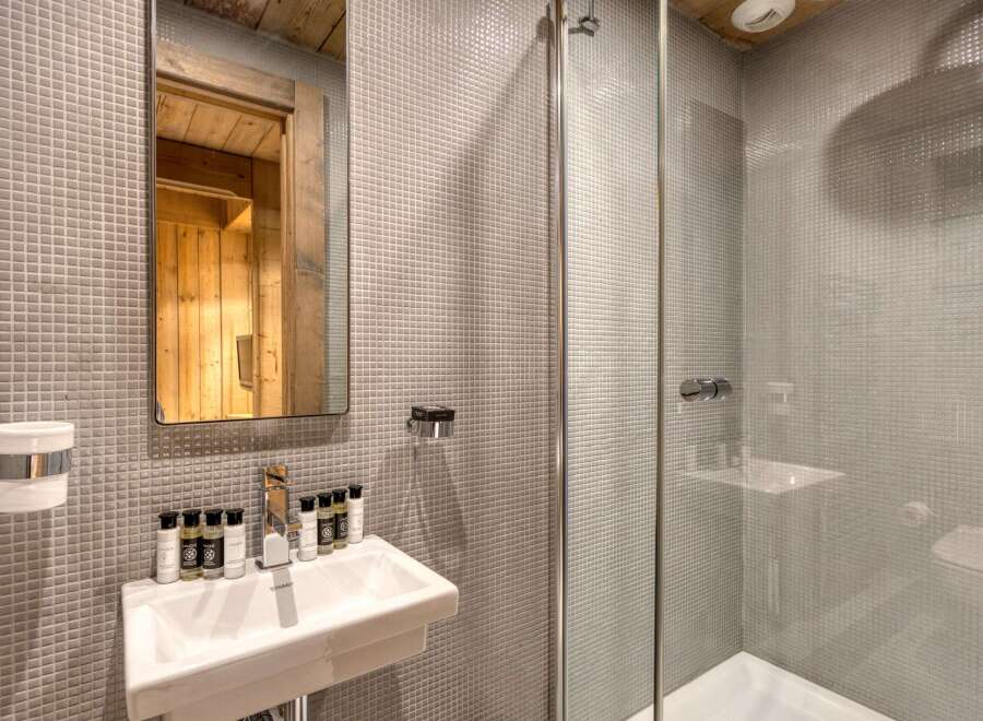 This modern bathroom boasts a sleek design with a glass shower enclosure and a stylish sink.