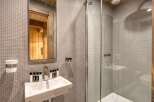 This modern bathroom boasts a sleek design with a glass shower enclosure and a stylish sink.