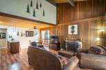 Step into this inviting living space, featuring a cozy fireplace and rustic wood paneling that exudes warmth and charm.