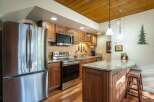 This stunning kitchen boasts stainless steel appliances, including a refrigerator, oven, and microwave, complemented by beautiful wooden cabinetry.