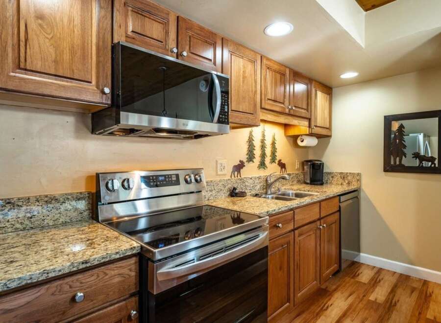 This stunning kitchen boasts beautiful wooden cabinetry and granite countertops, creating a warm and inviting atmosphere.