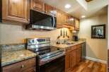 This stunning kitchen boasts beautiful wooden cabinetry and granite countertops, creating a warm and inviting atmosphere.