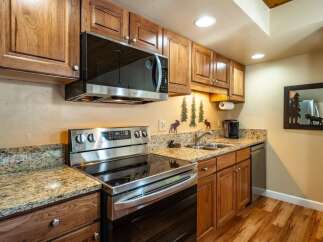This stunning kitchen boasts beautiful wooden cabinetry and granite countertops, creating a warm and inviting atmosphere.