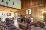 Step into rustic elegance with this stunning property, featuring a cozy living room with a fireplace and unique artwork.