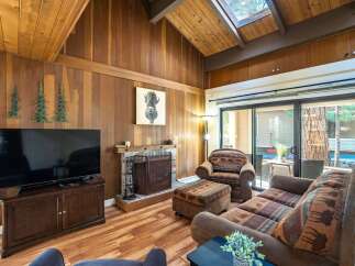 Step into this cozy living space, featuring a charming fireplace and a large flat-screen TV, perfect for relaxing evenings.