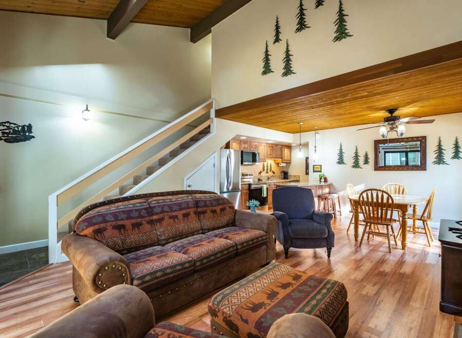 This stunning property features a cozy living room with a unique patterned sofa and a comfortable armchair.