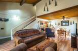 This stunning property features a cozy living room with a unique patterned sofa and a comfortable armchair.