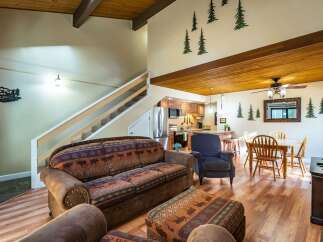 This stunning property features a cozy living room with a unique patterned sofa and a comfortable armchair.