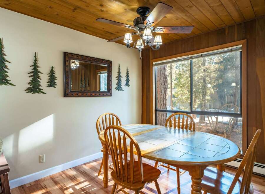 This charming dining area features a rustic wooden ceiling and walls, creating a warm and inviting atmosphere.