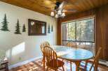 This charming dining area features a rustic wooden ceiling and walls, creating a warm and inviting atmosphere.