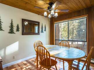 This charming dining area features a rustic wooden ceiling and walls, creating a warm and inviting atmosphere.