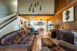 Step into rustic elegance with this stunning property, featuring a cozy living room with a fireplace and a comfortable seating area.