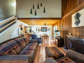 Step into rustic elegance with this stunning property, featuring a cozy living room with a fireplace and a comfortable seating area.