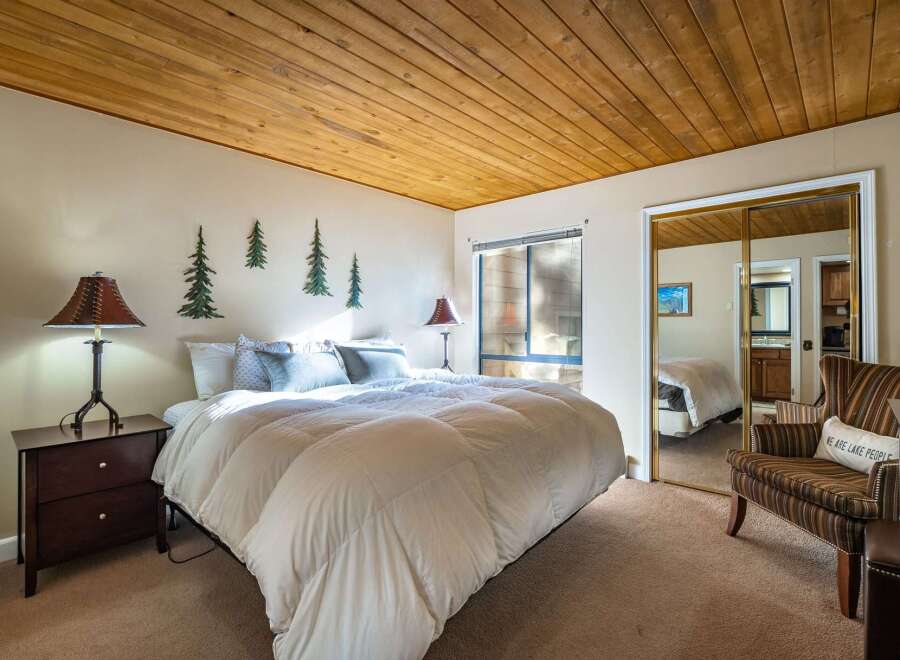 This cozy bedroom features a warm wooden ceiling and inviting decor.