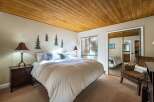 This cozy bedroom features a warm wooden ceiling and inviting decor.