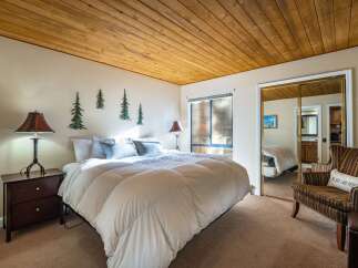 This cozy bedroom features a warm wooden ceiling and inviting decor.