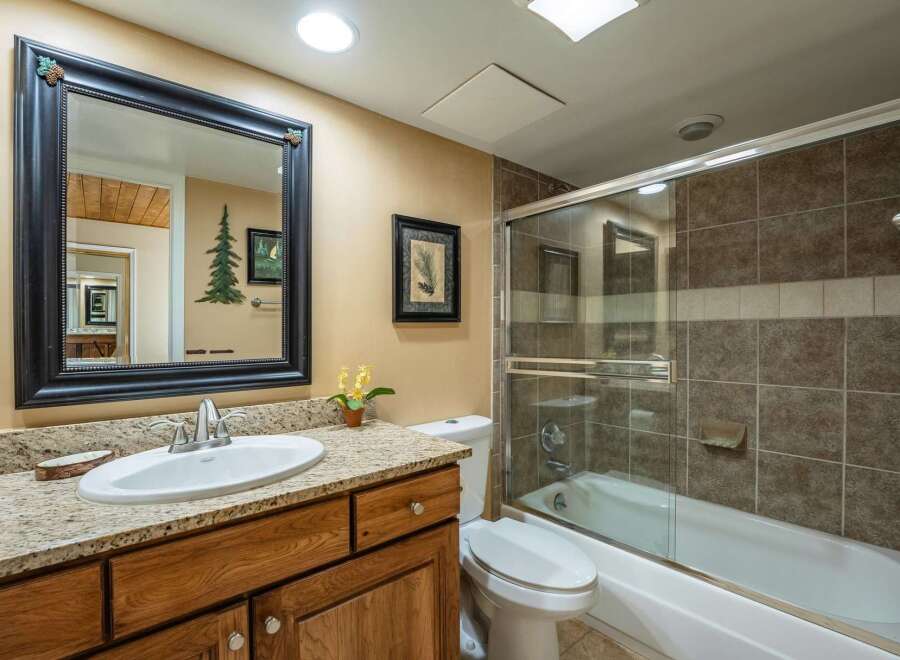 Step into this inviting bathroom, featuring a stylish vanity with a granite countertop and a sleek sink.