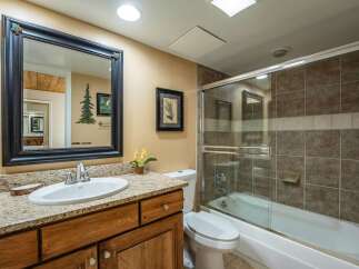 Step into this inviting bathroom, featuring a stylish vanity with a granite countertop and a sleek sink.