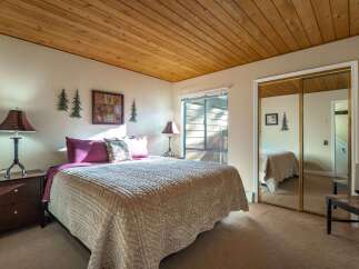 This cozy bedroom features a warm, inviting atmosphere with a wooden ceiling and neutral-toned walls.