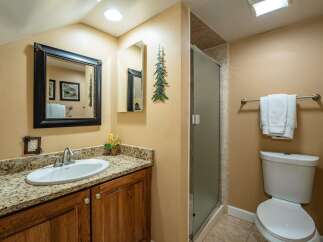 This charming bathroom features a stylish vanity with a granite countertop and a sleek, modern sink.