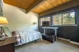 This cozy bedroom features a comfortable bed with a stylish plaid blanket and a warm, inviting ambiance.