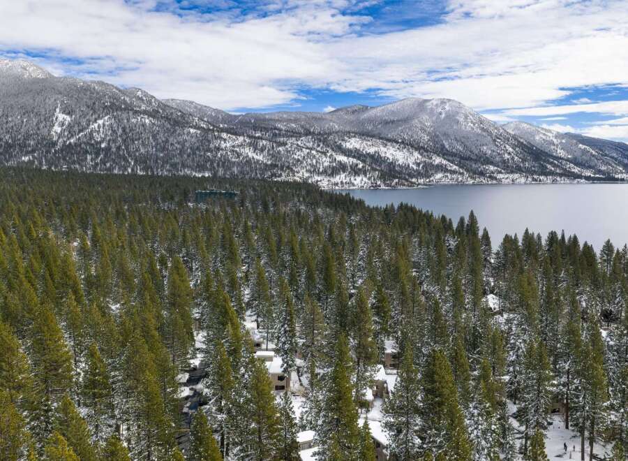 Nestled amidst a serene winter landscape, this property offers breathtaking views of snow-capped mountains and a tranquil lake.