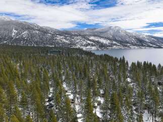 Nestled amidst a serene winter landscape, this property offers breathtaking views of snow-capped mountains and a tranquil lake.