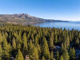 Discover a stunning property nestled amidst a lush forest with breathtaking lake views.