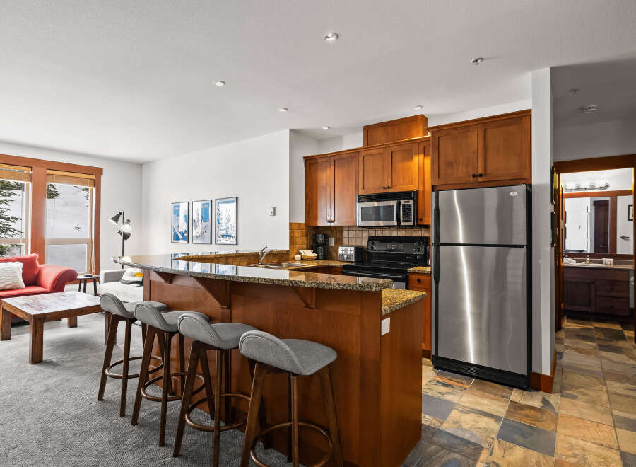 This stunning property boasts a modern kitchen with stainless steel appliances and a breakfast bar, perfect for entertaining.